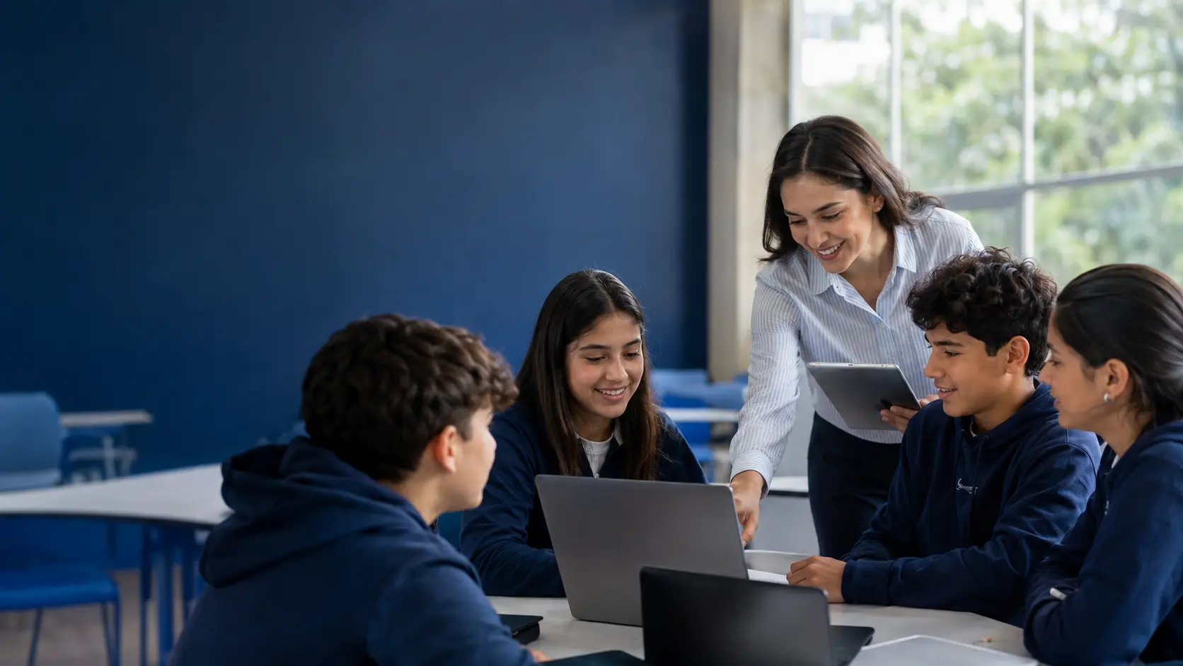 Docente y estudiantes utilizando tecnología para el seguimiento escolar